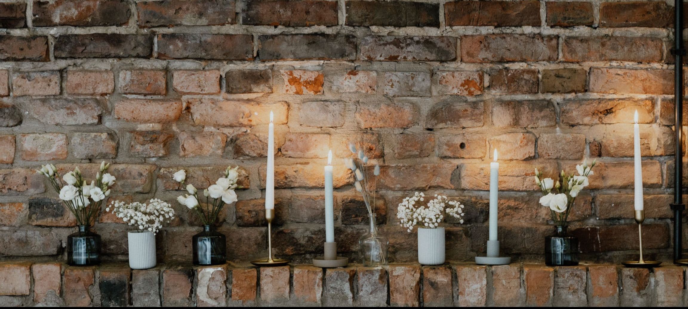 Delikatne kompozycje kwiatowe i świece na ceglanym murku | Warszawa | Praga