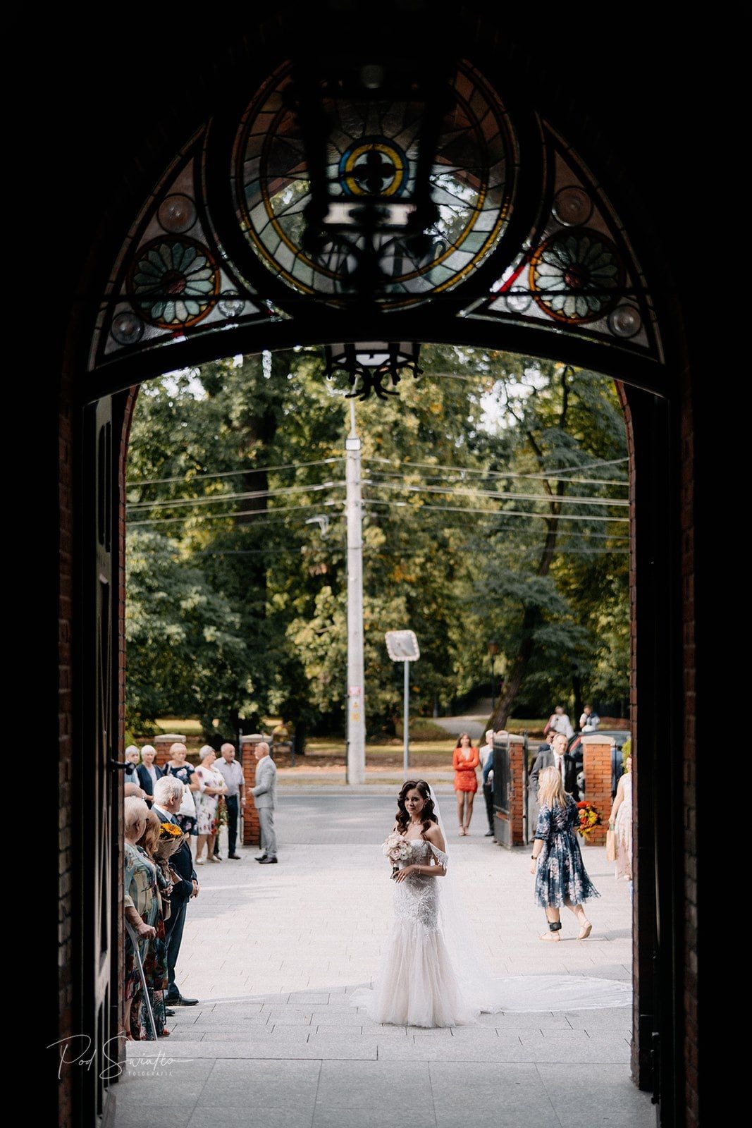 Panna Młoda z bukietem przed wejściem do kościoła 
