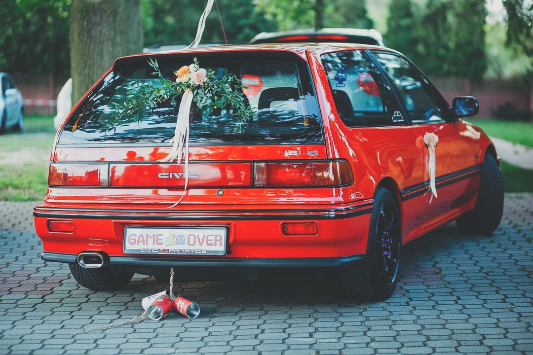 Dekoracja kwiatowa tylnej szyby samochodu do ślubu