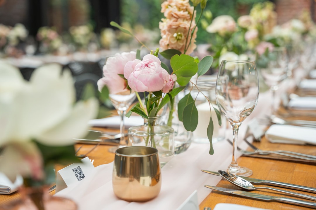 Elegancka dekoracja stołu weselnego z różowymi piwoniami i kieliszkami w rustykalnym stylu