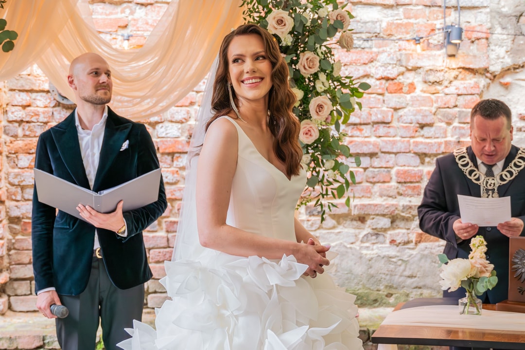 Ceremonia ślubna z panną młodą w białej sukni i kwiatową dekoracją