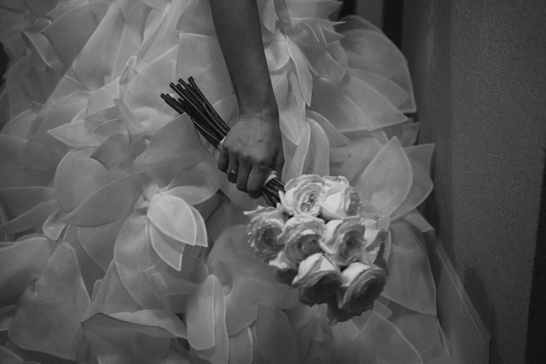 Bukiet ślubny z białych róż na delikatnej sukni panny młodej w klimacie romantycznym