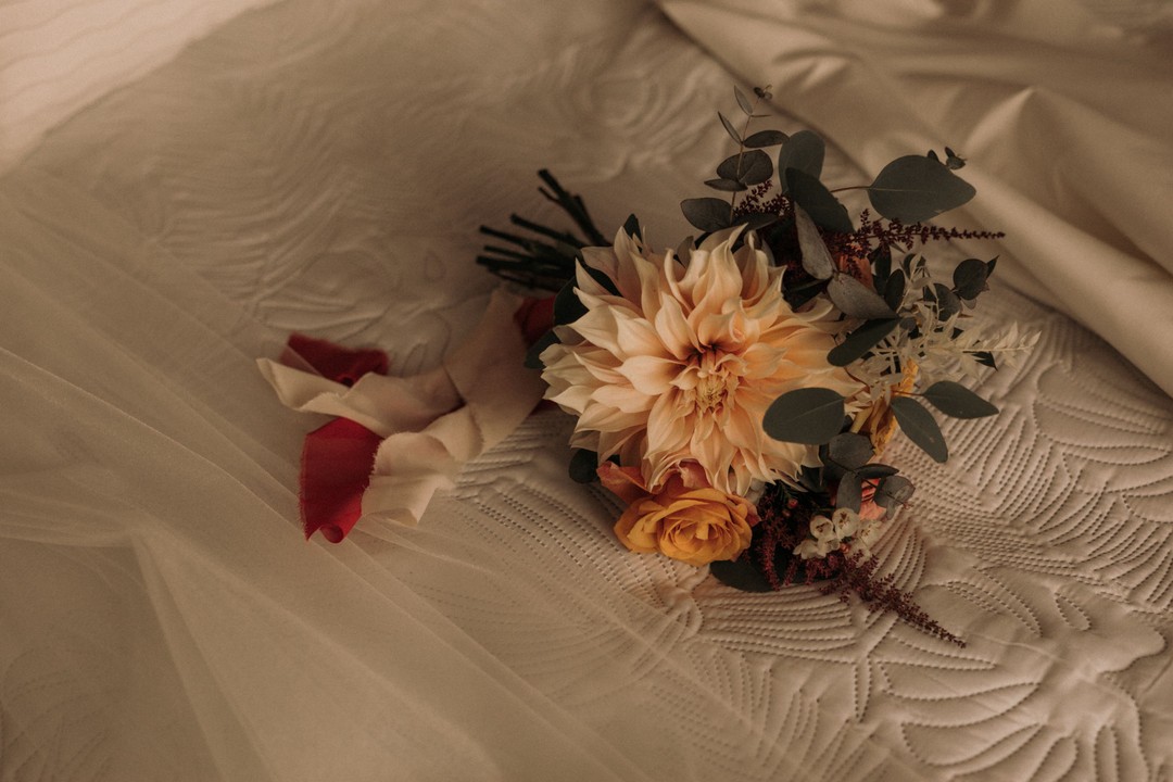 Bukiet na ślub z daliami oraz pomarańczowymi różami i eukaliptusem
