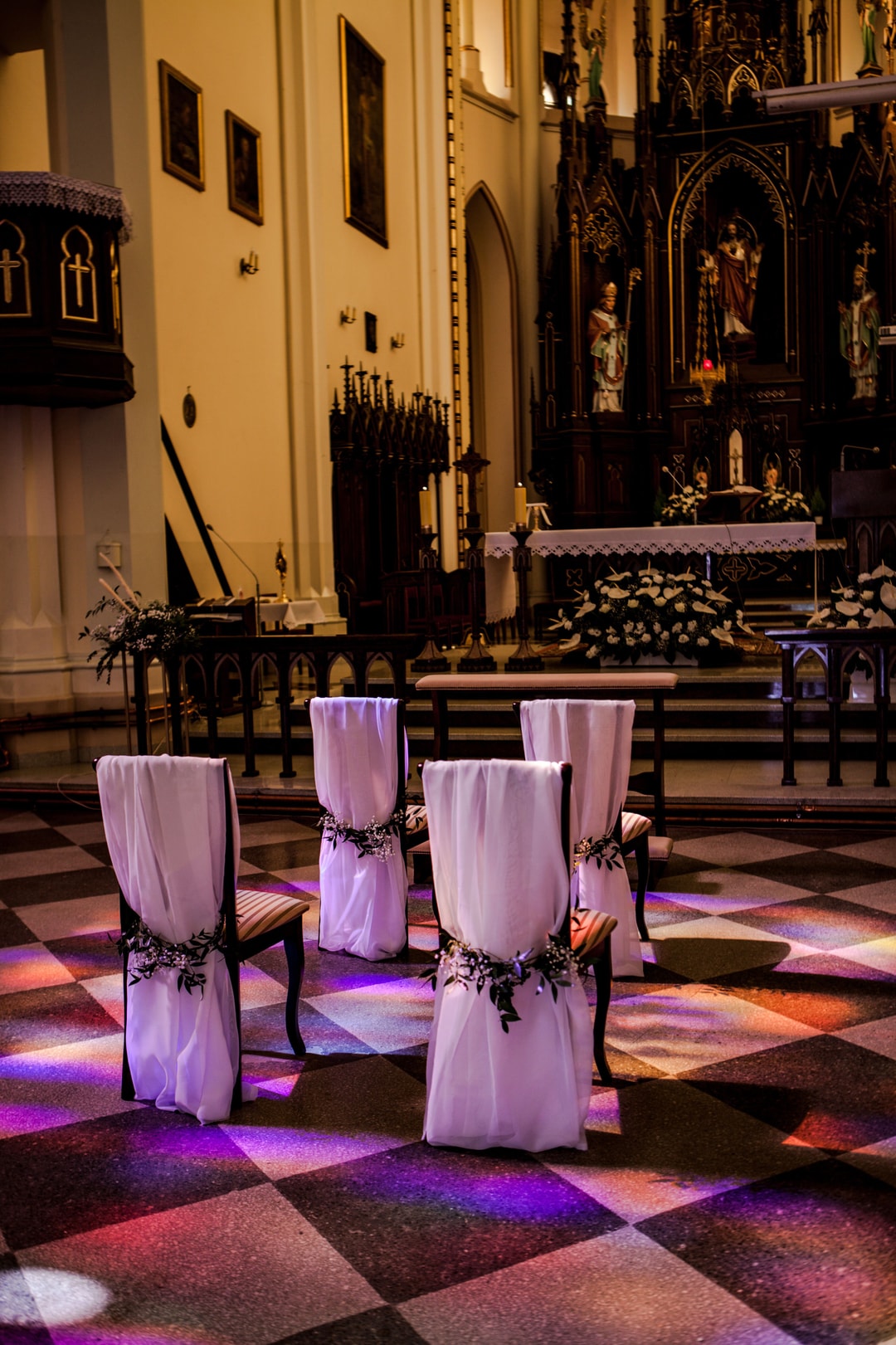 Dekoracja krzeseł woalem oraz drobnymi kwiatami i zielenią