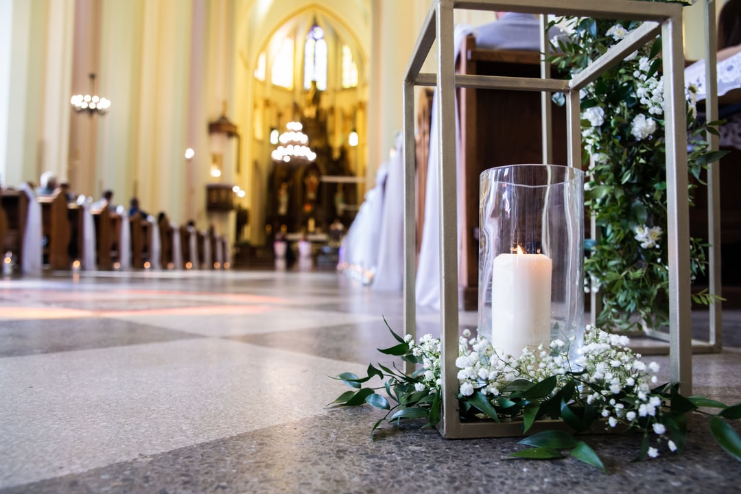 Niskie dekoracje kwiatowe kościoła oraz świeczniki.