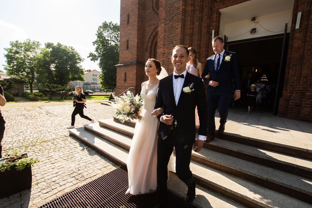 Panna młoda z bukietem oraz panowie z butonierkami