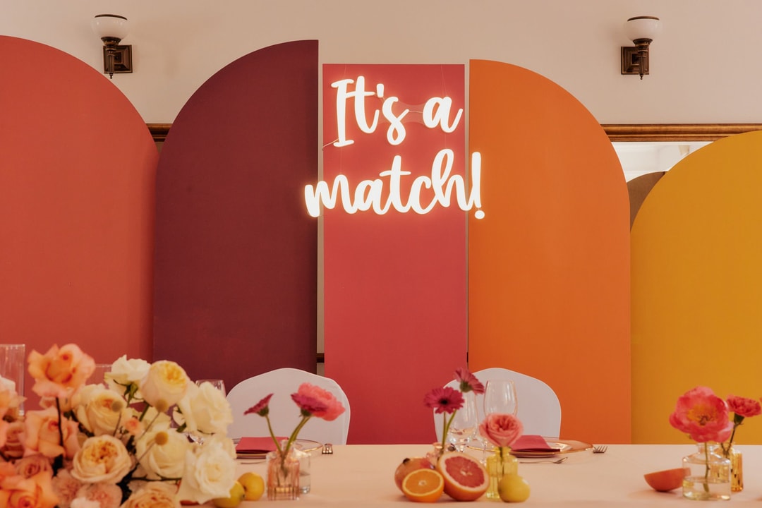 Kolorowe tło do dekoracji sali weselnej z łukami w tonach pomarańczu, czerwieni i żółci, napis It's a match