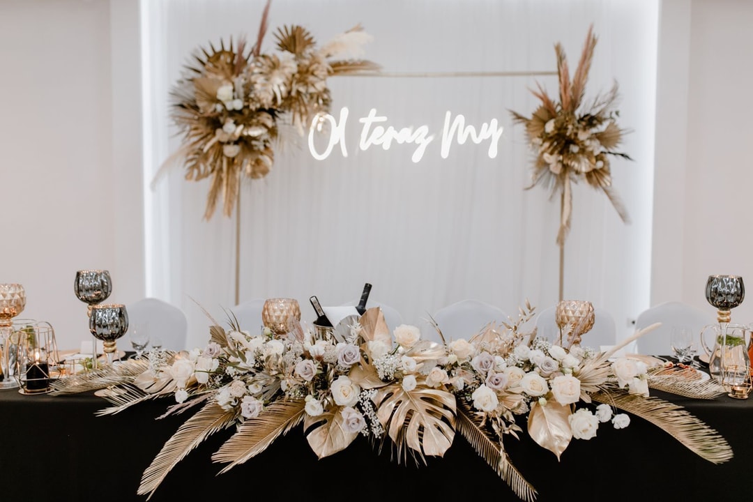 Złote liście w dekoracjach stołu prezydialnego.