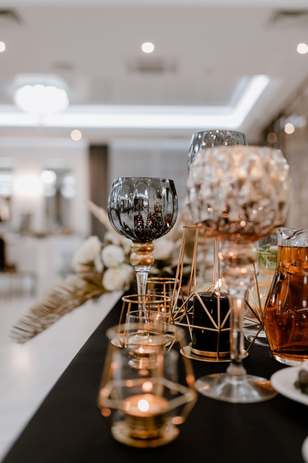 Kryształowe i metalowe świeczniki w kolorach przewodnich przyjęcia weselnego.