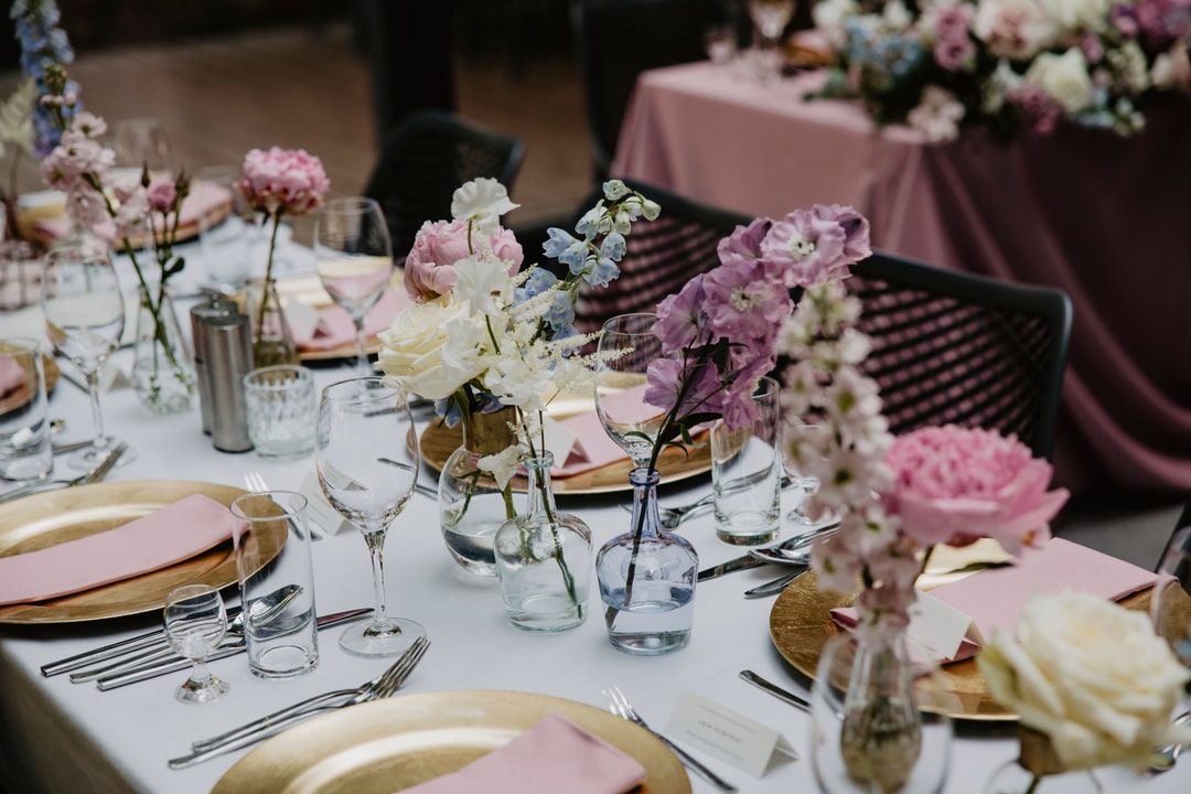 Kwiaty w kolorowych flakonikach na stołach gości