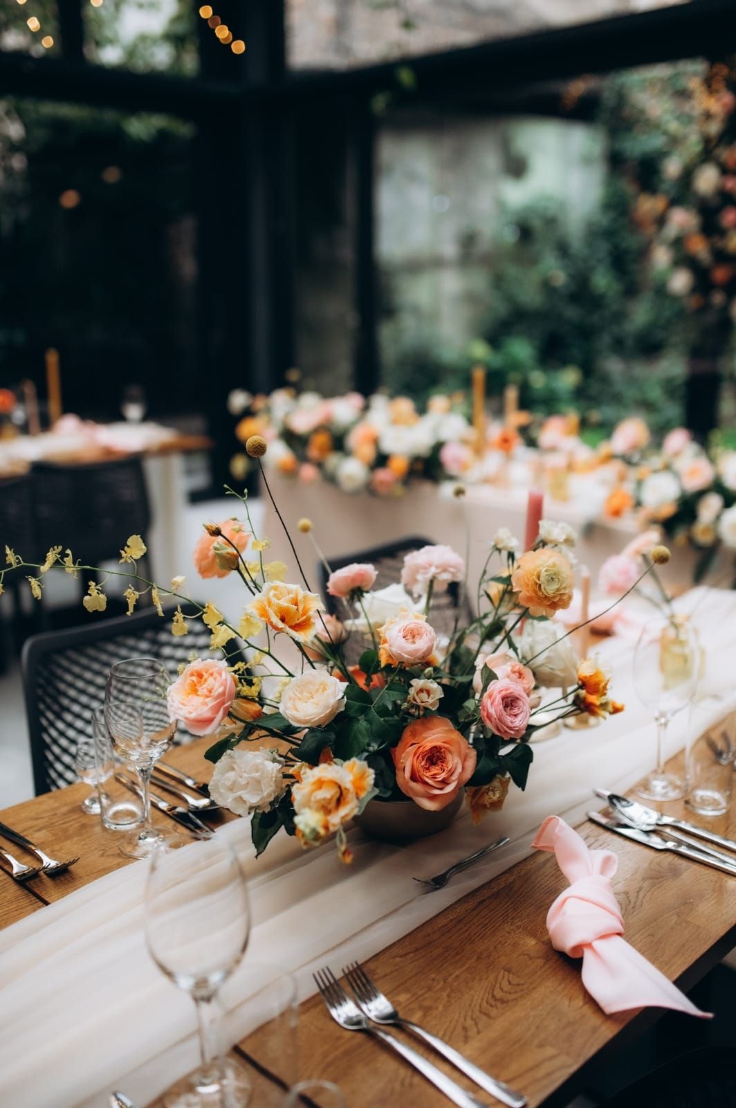 Композиция квіткова на стіл з трояндами в палітрі персику, кремовим та помаранчевим тоном на дерев'яному столі